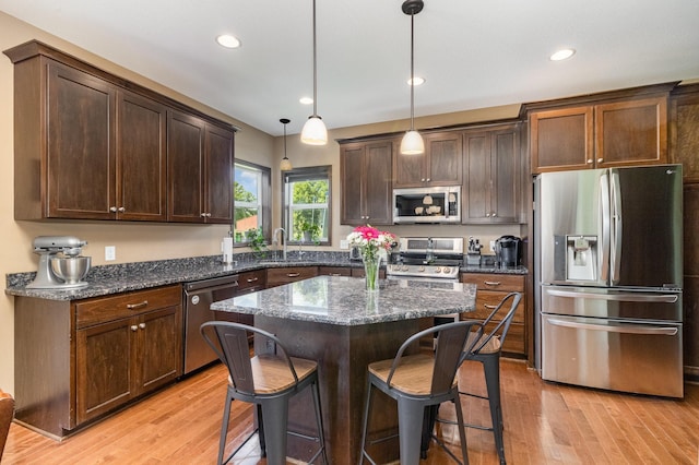 3410 Boulder Trl, Webster, MN 55088 - kitchen featuring stainless steel appliances, light wood-type flooring, a breakfast bar, dark brown cabinets, and recessed lighting