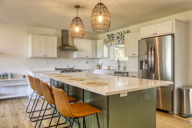 8112 Shore Trl N, Forest Lake, MN 55025 - kitchen with appliances with stainless steel finishes, wall chimney exhaust hood, white cabinetry, a center island, and light wood-style flooring