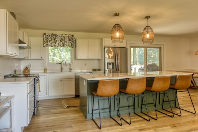 8112 Shore Trl N, Forest Lake, MN 55025 - kitchen with stainless steel appliances, white cabinets, light countertops, and a breakfast bar