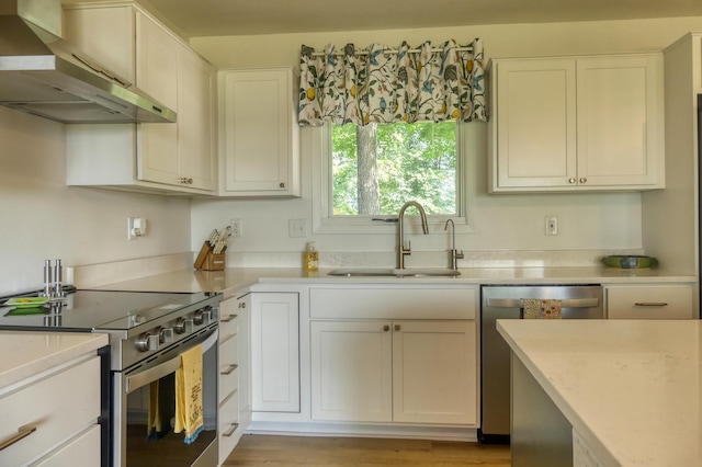 8112 Shore Trl N, Forest Lake, MN 55025 - kitchen featuring stainless steel appliances, wall chimney range hood, light countertops, and white cabinets