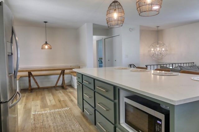 8112 Shore Trl N, Forest Lake, MN 55025 - kitchen with green cabinets, appliances with stainless steel finishes, light wood-type flooring, light countertops, and decorative light fixtures