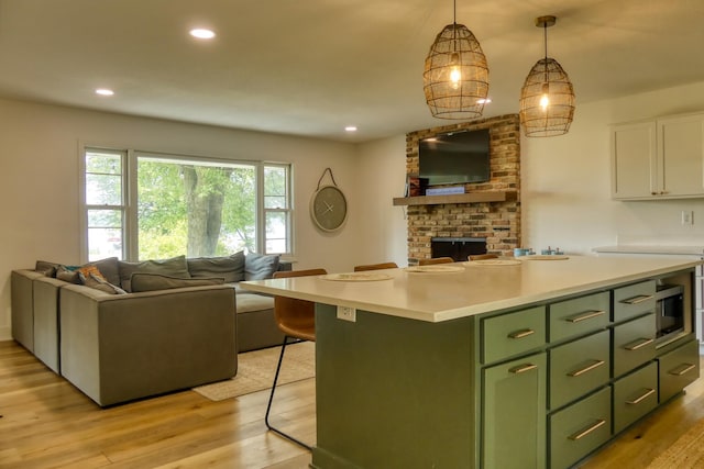 8112 Shore Trl N, Forest Lake, MN 55025 - kitchen featuring green cabinets, open floor plan, white cabinets, light countertops, and a center island