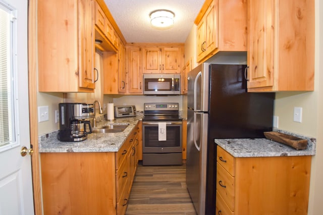 14590 Gazebo Dr Unit 10, Park Rapids, MN 56470 - kitchen featuring appliances with stainless steel finishes, dark wood-style flooring, light stone counters, and a textured ceiling