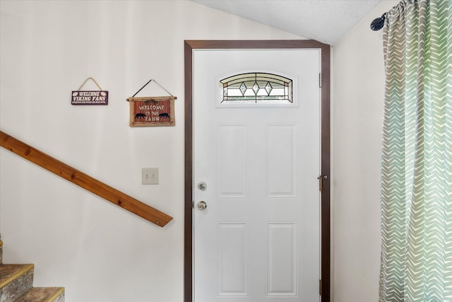 36977 Shoreland Rd, Sturgeon Lake, MN 55783 - entrance foyer with vaulted ceiling, stairs, and a textured ceiling