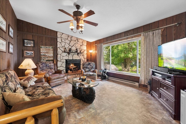36977 Shoreland Rd, Sturgeon Lake, MN 55783 - living area featuring wood walls, vaulted ceiling, ceiling fan, a stone fireplace, and a baseboard radiator
