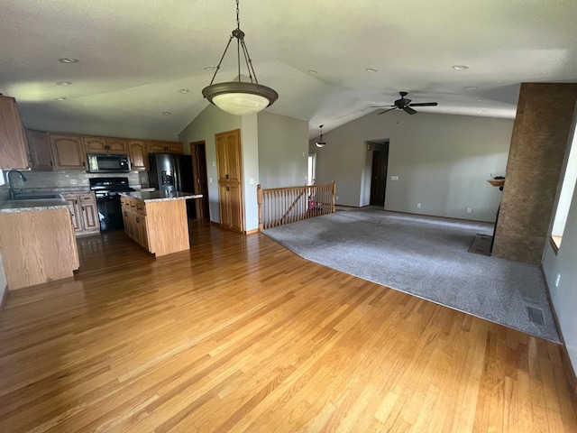 13205 Lake Place Rd, Baldwin Twp, MN 55398 - kitchen with black appliances, open floor plan, vaulted ceiling, wood finished floors, and a center island