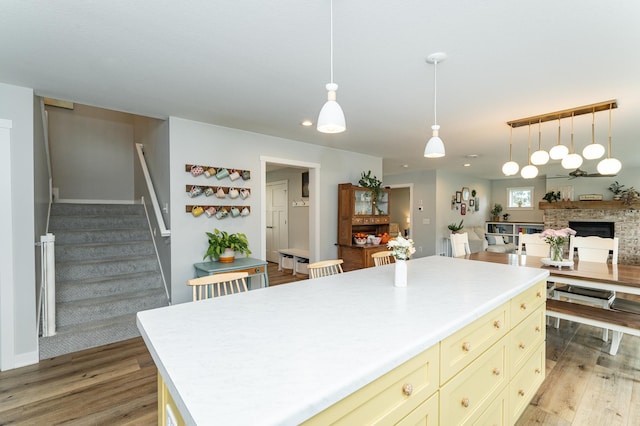 2990 Pinewood Ridge Dr SE, Rochester, MN 55904 - kitchen with a fireplace, light wood-type flooring, light countertops, cream cabinetry, and recessed lighting