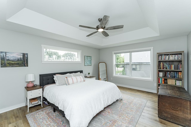 2990 Pinewood Ridge Dr SE, Rochester, MN 55904 - bedroom featuring a tray ceiling, wood finished floors, and a ceiling fan