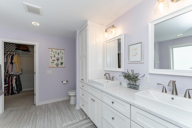 2990 Pinewood Ridge Dr SE, Rochester, MN 55904 - bathroom with double vanity, a walk in closet, and recessed lighting