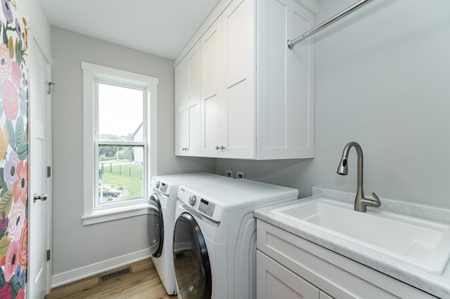 2990 Pinewood Ridge Dr SE, Rochester, MN 55904 - laundry room with cabinet space, washer and clothes dryer, plenty of natural light, and light wood-style floors
