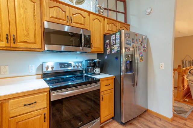 44198 Mosquito Trl, Pine Lake Twp, MN 56573 - kitchen with stainless steel appliances, light countertops, light wood-style floors, and brown cabinetry