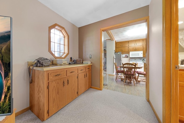 600 168th St, Summit Twp, MN 56026 - kitchen featuring white microwave, stove, light carpet, light countertops, and freestanding refrigerator