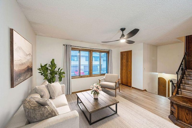 8431 Toledo Ave N, Brooklyn Park, MN 55443 - living area featuring ceiling fan, stairway, light wood-style floors, and a textured ceiling