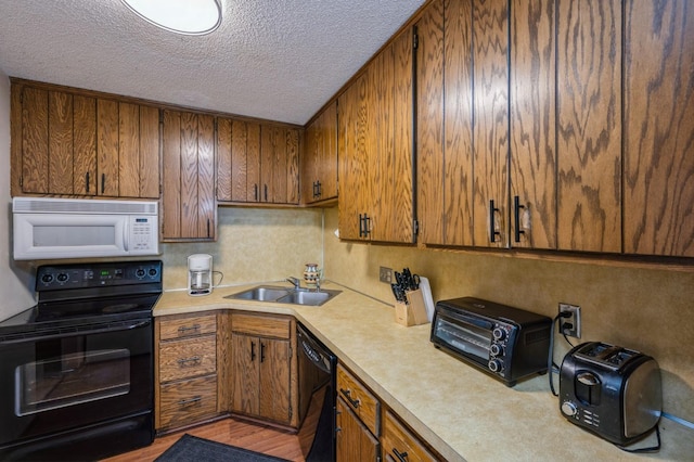 8431 Toledo Ave N, Brooklyn Park, MN 55443 - kitchen with black appliances, light countertops, brown cabinets, and a textured ceiling