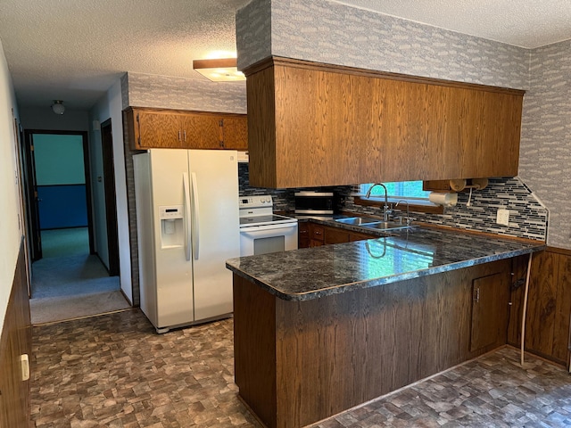 925 Holcombe Ave, Litchfield, MN 55355 - kitchen with white appliances, a peninsula, a textured ceiling, tasteful backsplash, and brown cabinets