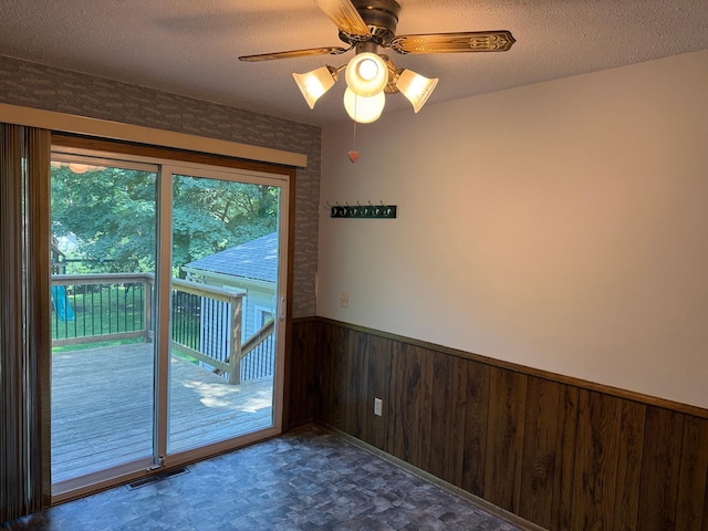 925 Holcombe Ave, Litchfield, MN 55355 - doorway featuring wainscoting, wooden walls, a textured ceiling, and a ceiling fan