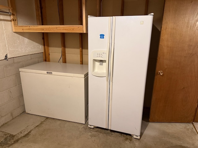 925 Holcombe Ave, Litchfield, MN 55355 - kitchen featuring white fridge with ice dispenser, concrete flooring, fridge, concrete block wall, and light countertops