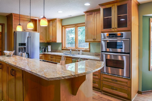 12310 Grouse St NW, Coon Rapids, MN 55448 - kitchen featuring appliances with stainless steel finishes, light wood-style flooring, light stone countertops, a textured ceiling, and glass insert cabinets