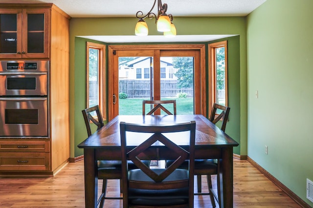 12310 Grouse St NW, Coon Rapids, MN 55448 - dining area featuring light wood finished floors and a chandelier