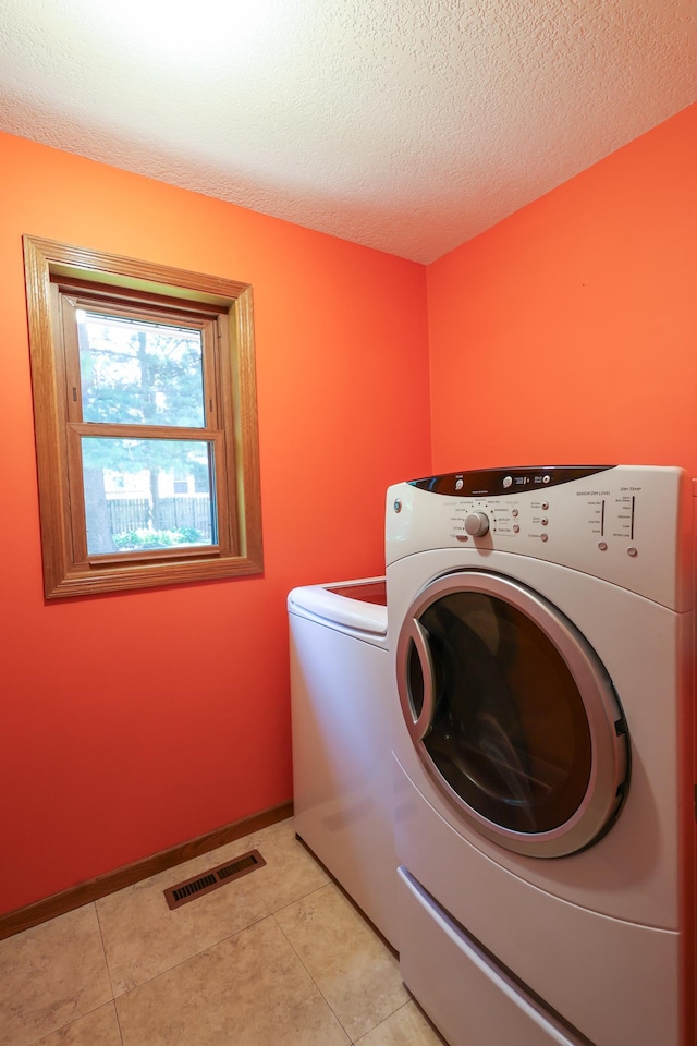12310 Grouse St NW, Coon Rapids, MN 55448 - washroom with washing machine and clothes dryer, a textured ceiling, and light tile patterned floors