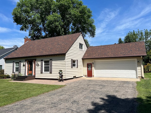 1010 Oakwood Ave, Benson, MN 56215 - view of front of house with roof with shingles, a front yard, a chimney, asphalt driveway, and a garage