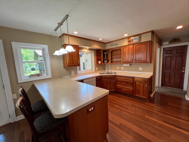 1010 Oakwood Ave, Benson, MN 56215 - kitchen featuring brown cabinets, a peninsula, a textured ceiling, open shelves, and a breakfast bar area