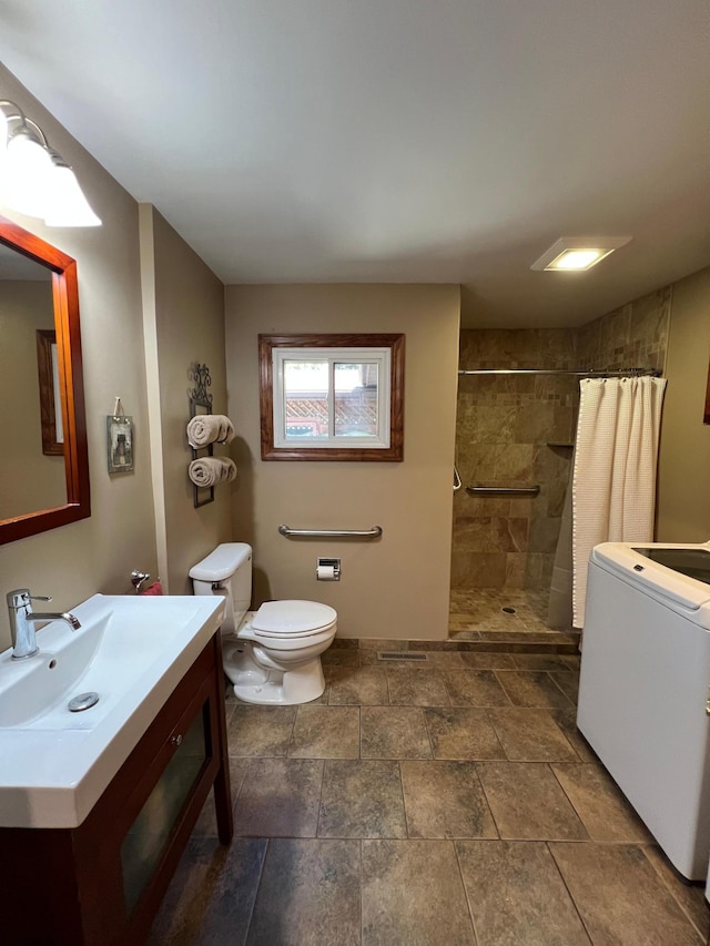 1010 Oakwood Ave, Benson, MN 56215 - bathroom with washer / dryer, vanity, a tile shower, and stone finish floors