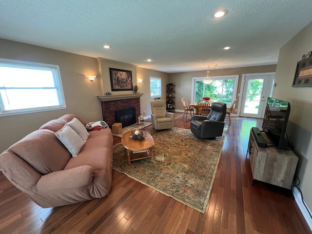 1010 Oakwood Ave, Benson, MN 56215 - living area featuring a textured ceiling, dark wood-style floors, plenty of natural light, a glass covered fireplace, and recessed lighting