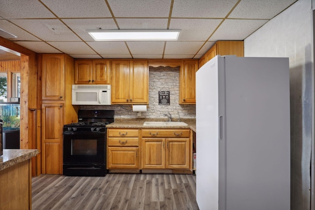 1060 Greer Ave NW, Albion Twp, MN 55358 - kitchen featuring white appliances, a drop ceiling, light wood-type flooring, brown cabinetry, and tasteful backsplash