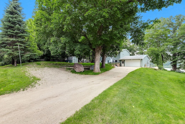 1060 Greer Ave NW, Albion Twp, MN 55358 - view of property hidden behind natural elements featuring a front yard, driveway, a shed, and an attached garage