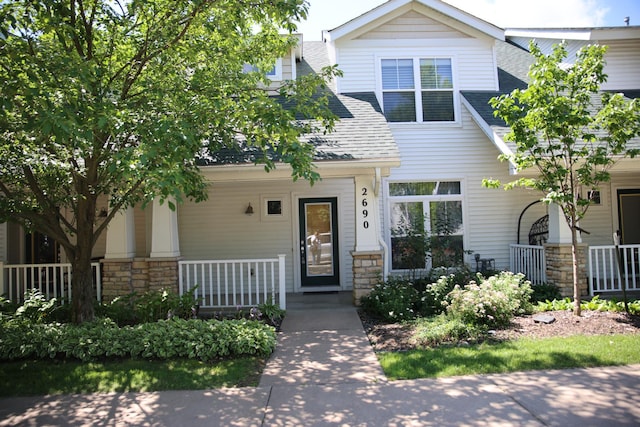2690 Pinkspire Ln E, Maplewood, MN 55119 - view of front facade featuring covered porch, stone siding, and a shingled roof