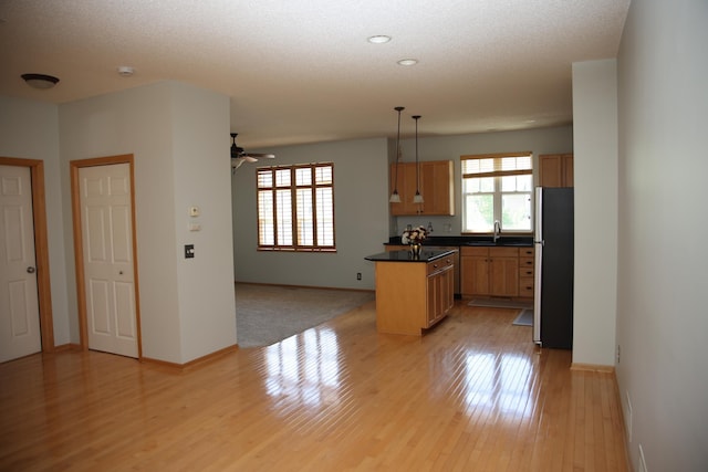 2690 Pinkspire Ln E, Maplewood, MN 55119 - kitchen featuring freestanding refrigerator, a kitchen island, open floor plan, light wood-type flooring, and dark countertops