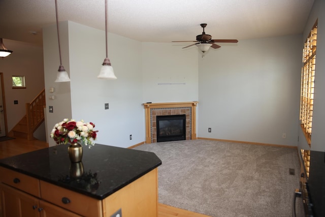 2690 Pinkspire Ln E, Maplewood, MN 55119 - kitchen with a ceiling fan, dark countertops, a fireplace, decorative light fixtures, and a center island