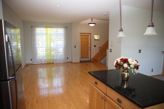 2690 Pinkspire Ln E, Maplewood, MN 55119 - kitchen featuring freestanding refrigerator, light wood-type flooring, decorative light fixtures, and dark stone counters