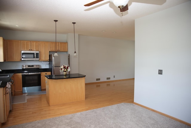 2690 Pinkspire Ln E, Maplewood, MN 55119 - kitchen featuring appliances with stainless steel finishes, a kitchen island, a ceiling fan, dark countertops, and light wood-type flooring