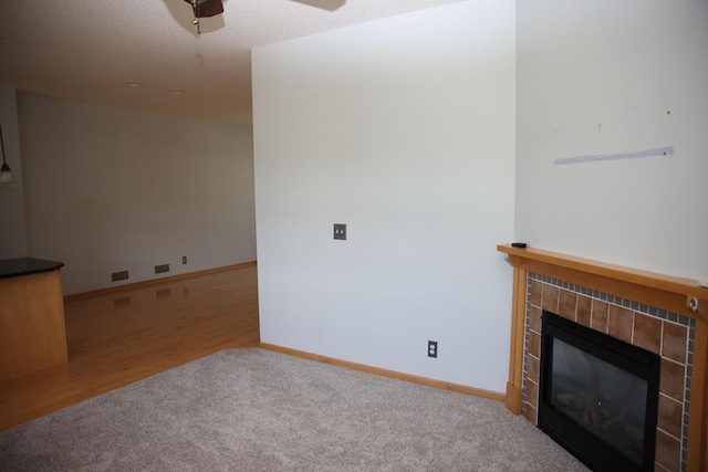 2690 Pinkspire Ln E, Maplewood, MN 55119 - unfurnished living room featuring a tiled fireplace, a ceiling fan, carpet flooring, and wood finished floors
