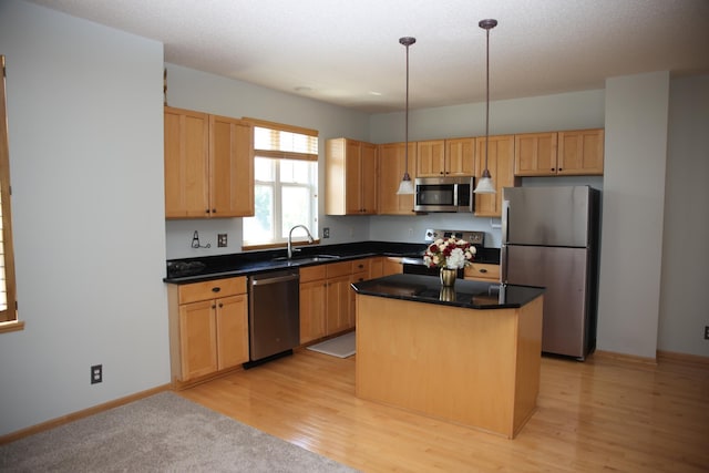 2690 Pinkspire Ln E, Maplewood, MN 55119 - kitchen with appliances with stainless steel finishes, a kitchen island, dark countertops, and light wood-style flooring