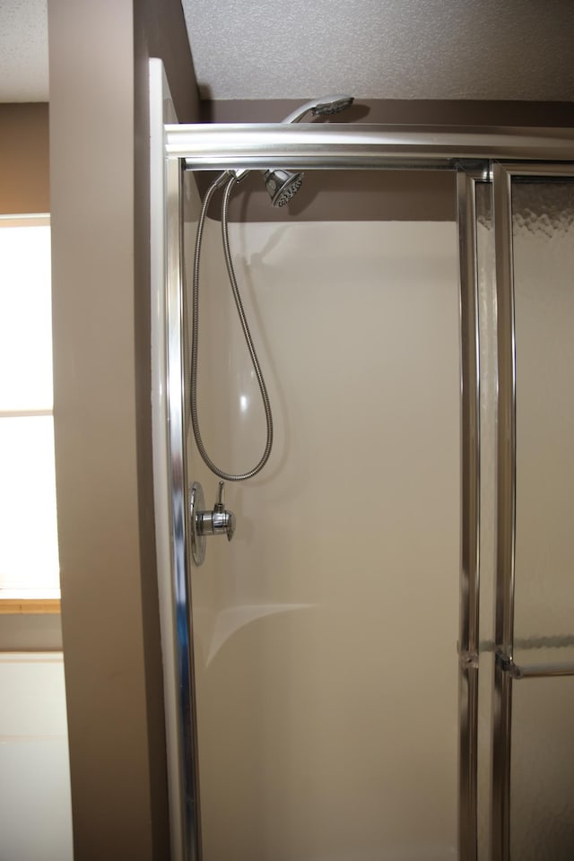 2690 Pinkspire Ln E, Maplewood, MN 55119 - full bath with a shower with shower door and a textured ceiling
