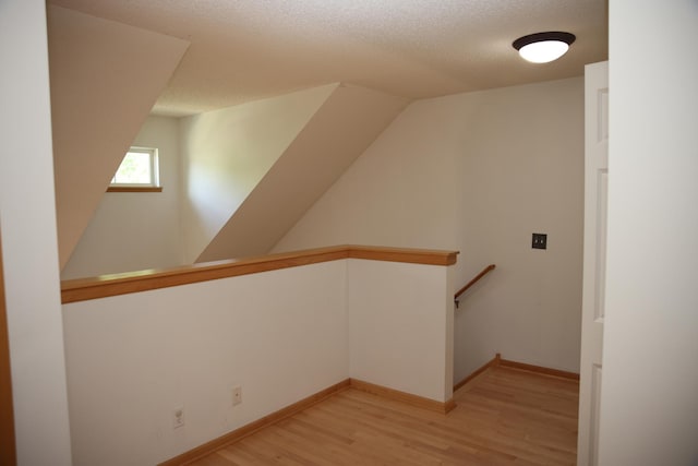 2690 Pinkspire Ln E, Maplewood, MN 55119 - additional living space featuring light wood-type flooring and a textured ceiling