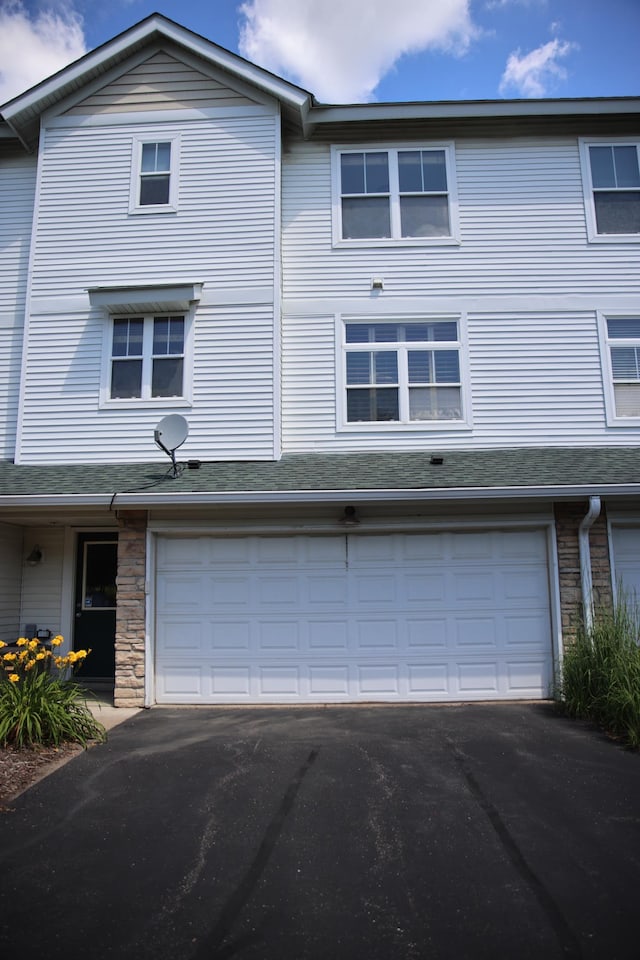 2690 Pinkspire Ln E, Maplewood, MN 55119 - view of front of home with a garage, driveway, and stone siding