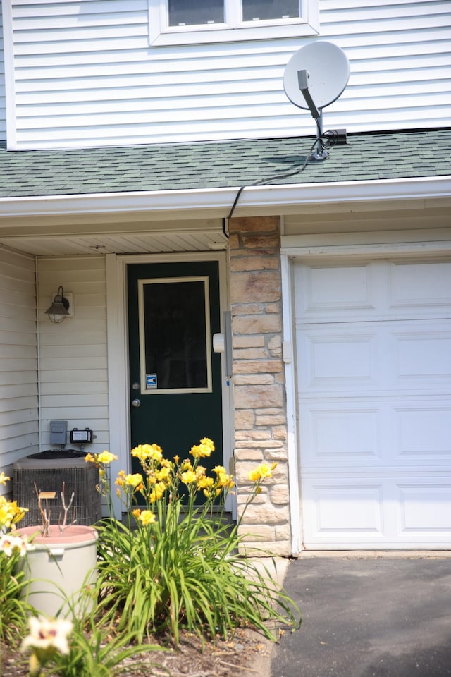 2690 Pinkspire Ln E, Maplewood, MN 55119 - doorway to property with a garage, a shingled roof, and covered porch