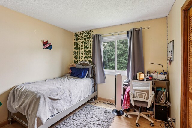 9205 29th Ave N, New Hope, MN 55427 - bedroom with a textured ceiling, an office area, and wood finished floors