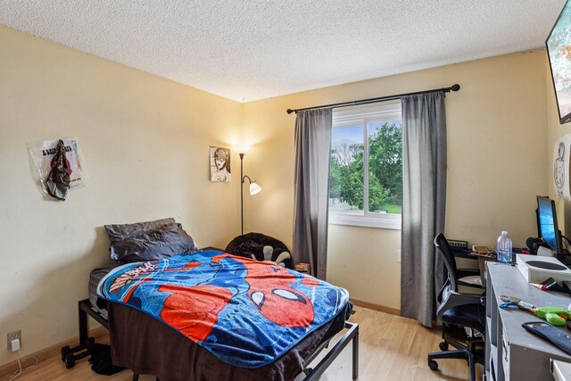 9205 29th Ave N, New Hope, MN 55427 - bedroom featuring light wood-type flooring, a textured ceiling, and a desk