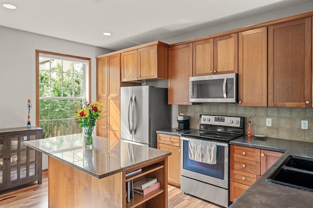 8291 Labont Way, Eden Prairie, MN 55344 - kitchen with stainless steel appliances, recessed lighting, light wood-style flooring, decorative backsplash, and a kitchen island
