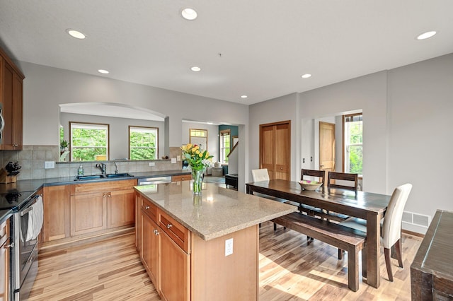 8291 Labont Way, Eden Prairie, MN 55344 - kitchen with light wood-style flooring, electric range, a center island, recessed lighting, and decorative backsplash