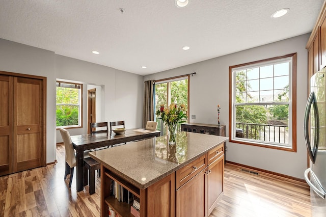 8291 Labont Way, Eden Prairie, MN 55344 - kitchen featuring light wood-style flooring, a center island, freestanding refrigerator, plenty of natural light, and recessed lighting