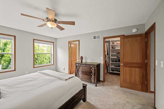 8291 Labont Way, Eden Prairie, MN 55344 - bedroom with a spacious closet, light carpet, ceiling fan, and ensuite bathroom