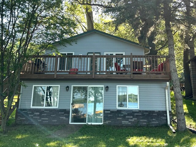10285 237th Ave, Spirit Lake, IA 51360 - back of property with a lawn, a wooden deck, and stone siding