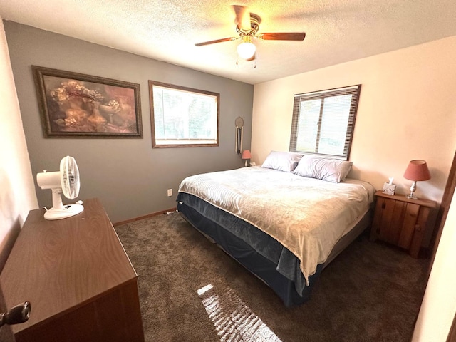 10285 237th Ave, Spirit Lake, IA 51360 - bedroom with dark carpet, a textured ceiling, and ceiling fan