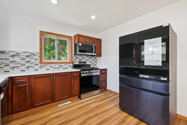 8341 Abbott Ave N, Brooklyn Park, MN 55443 - kitchen featuring black appliances, light countertops, light wood finished floors, tasteful backsplash, and recessed lighting